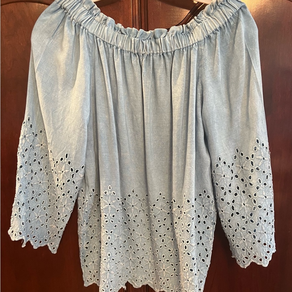 Off shoulder light blue blouse with eyelet on sleeves and bottom of blouse.